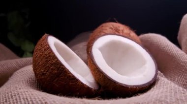 Hindistan cevizi ikiye bölünmüş, tahtanın üstünde hindistan cevizi talaşı var.