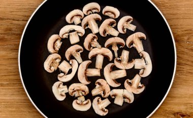 Ahşap arka plan üzerinde bir tavada mantar