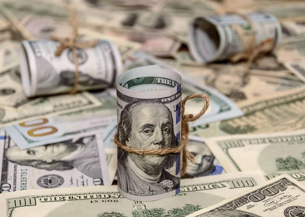 Hundra dollarsedlar rullas upp på dollar bakgrund — Stockfoto