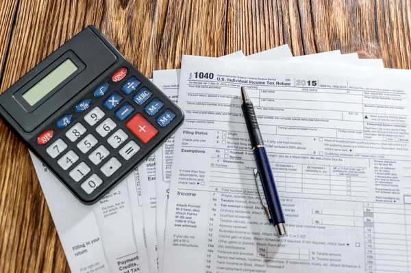 Steuerformular 1040 mit Stift und Taschenrechner auf dem Tisch — Stockfoto