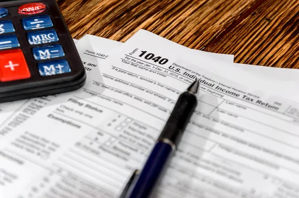 Formulario fiscal 1040 con pluma y calculadora sobre la mesa — Foto de Stock