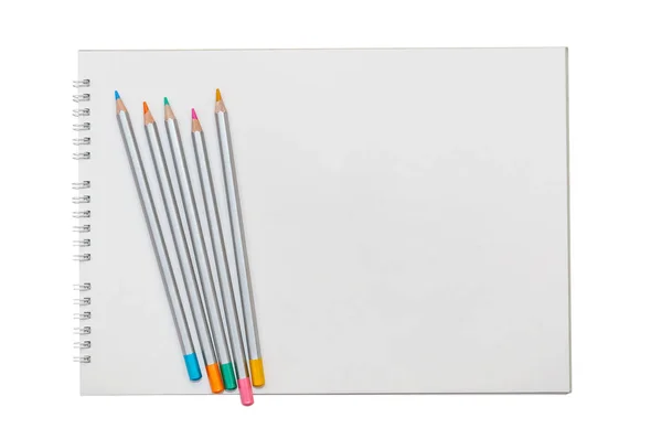 Multicolored pencils on the album for drawing isolated on white — Stock Photo, Image