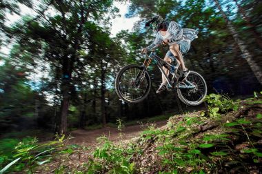 Moscow, Rusya Federasyonu - 21 Ağustos 2017: Atlama ve dağ bisikleti üzerinde uçmak. Binici dağ bisiklet spor eylem. Ormanda sürme motorcu. Serin atlet bisikletçi bir bisiklet. Mtb bisikleti.