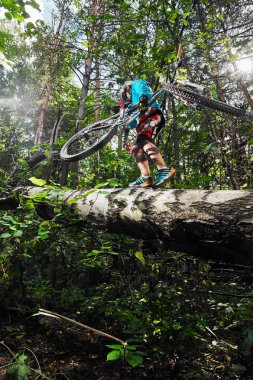 Moskova, Rusya - 21 Ağustos 2017: dağ bisikleti. Bisikletçi ormanda bisiklet taşıyor..