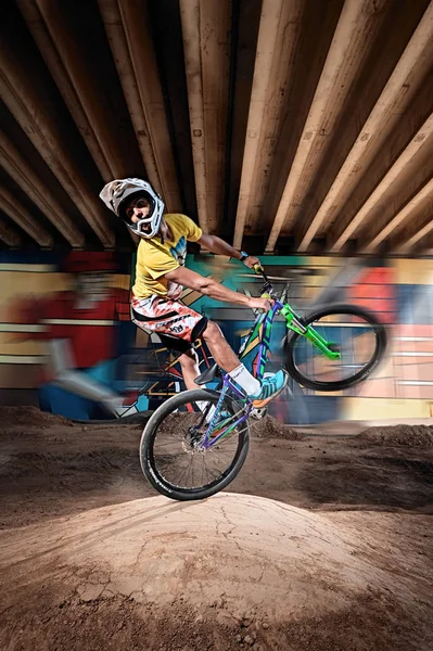 Dağ bisikleti bisikletçi bir mtb bisiklet üzerinde wheelie dublör yapıyor