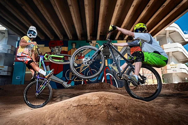 Dağ bisikletçileri bir mtb bisiklet üzerinde wheelie dublör yapıyor. Motorcu aşırı spor bisiklet sürme. Bisikletli havalı atlet bisikletçi. Mtb bisiklet.