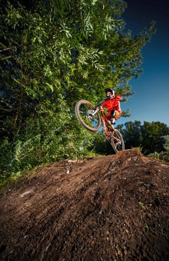 Dağ bisikleti bisikletçi bir mtb bisiklet üzerinde wheelie dublör yapıyor.