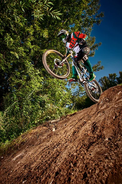 Dağ bisikleti bisikletçi bir mtb bisiklet üzerinde wheelie dublör yapıyor. 