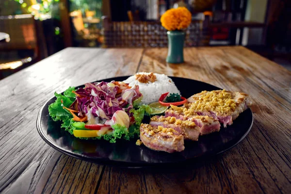Bife de atum grelhado com arroz e legumes no interior de um café — Fotografia de Stock