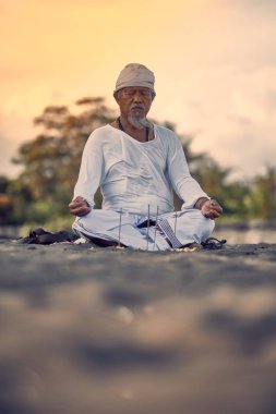 Bali, Endonezya - 12 Aralık 2019: Meditasyon yapan yaşlı yerel balili adam