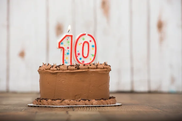 Chocolate frosted cake with  one and zero candle on top.  Tenth — Stock Photo, Image