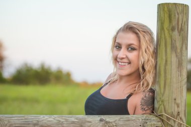 Güzel sarışın kadın çit yazı üzerine eğilerek