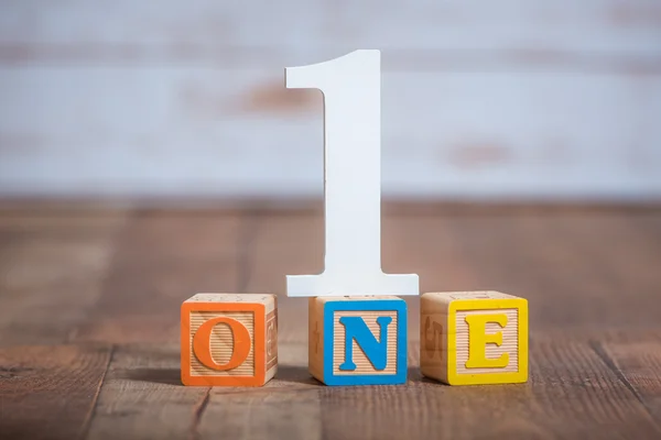 One in the number and wooden blocks spelled out — Stock Photo, Image
