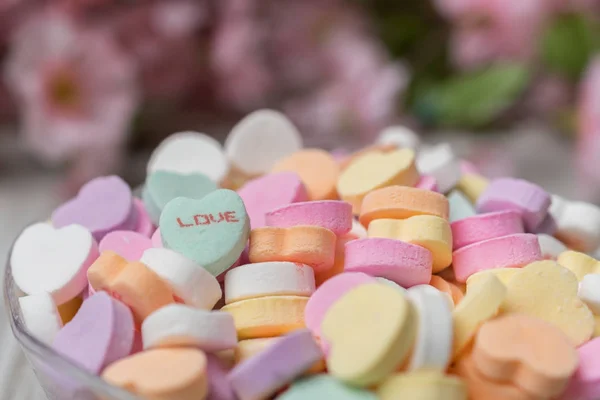 Bowl of valentines heart candy with messages.  Focus is on Love.