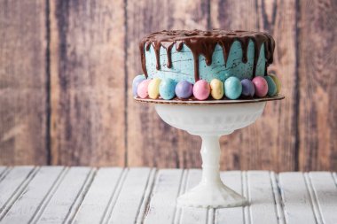 Mavi buzlu kek çikolata damla buzlanma ve rustik bir ortamda Paskalya yumurtaları