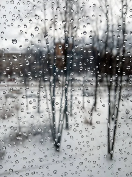 Regndroppar på glaset, regn på det nya året, regn med snö, vått väder, regnigt väder, depression, grå himmel — Stockfoto