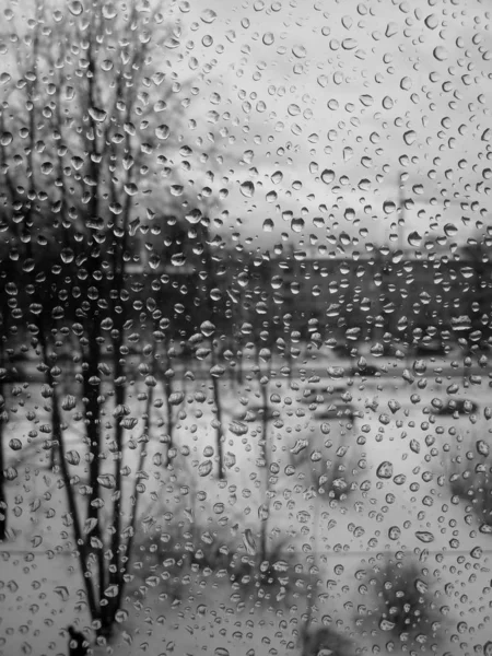 Camdaki yağmur damlaları, yeni yılda yağmur, karlı yağmur, ıslak hava, yağmurlu hava, depresyon, gri gökyüzü