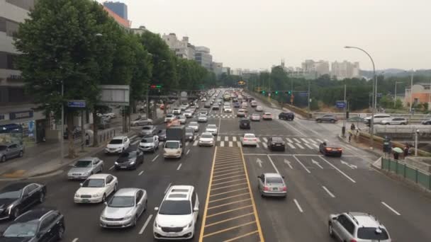 Statik hava atış tipik büyük şehirde Asya. Rainly hava, yüksek trafik sokakta insanlar yürümek. — Stok video