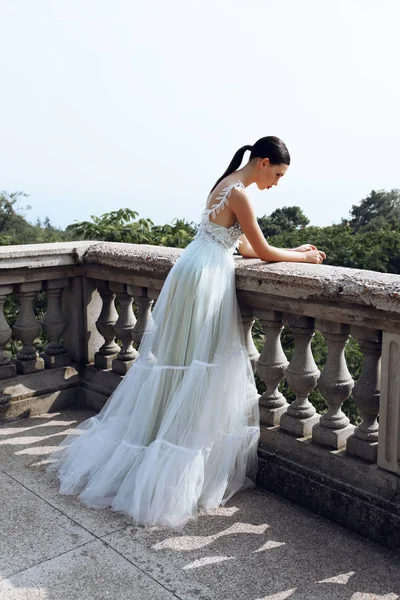 Linda noiva jovem com cabelo escuro no vestido de noiva elegante — Fotografia de Stock