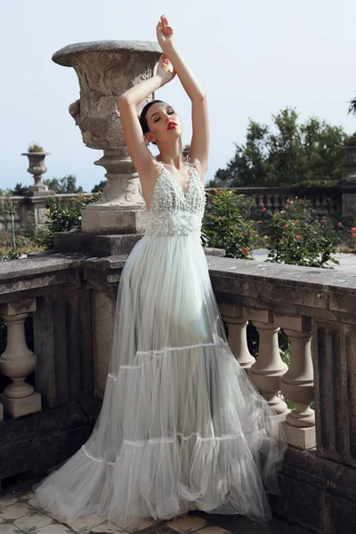 Великолепная молодая невеста с темными волосами в элегантном свадебном платье — стоковое фото