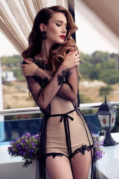 Prachtige vrouw met donker krullend haar in luxe outfit — Stockfoto