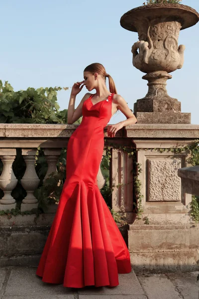 Magnifique jeune femme aux cheveux foncés dans une élégante robe rouge — Photo