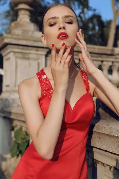 Hermosa mujer joven con cabello oscuro en vestido rojo elegante —  Fotos de Stock