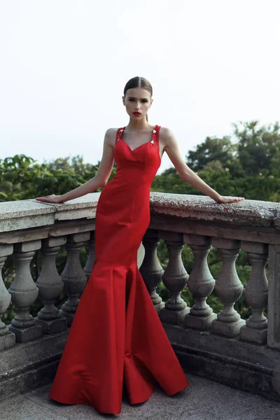 Magnifique jeune femme aux cheveux foncés dans une élégante robe rouge — Photo