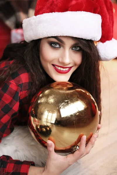 Encantadora mujer con el pelo oscuro posando cerca del árbol de Navidad —  Fotos de Stock