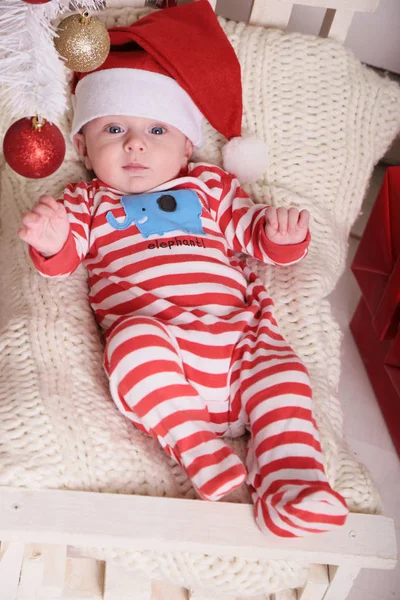 Söt liten Santa baby på mysiga hem med nyår dekoration — Stockfoto