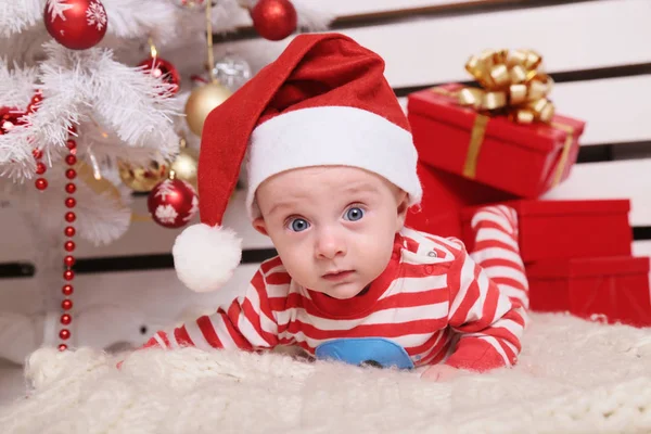 Милый маленький Санта ребенок в уютном доме с новогодней отделкой — стоковое фото