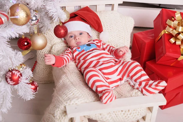 Милый маленький Санта ребенок в уютном доме с новогодней отделкой — стоковое фото