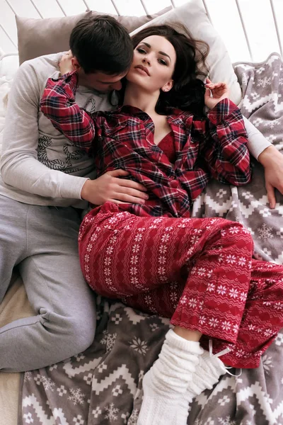 Нежная пара в уютной домашней одежде позирует в спальне — стоковое фото