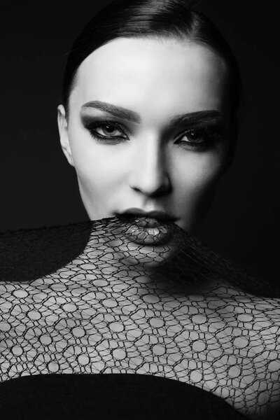Fashion studio portrait of gorgeous sensual woman with dark hair with transparent veil on face