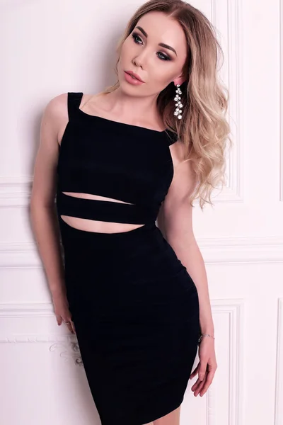 Nádherná žena s blond vlasy v elegantní černé šaty — Stock fotografie