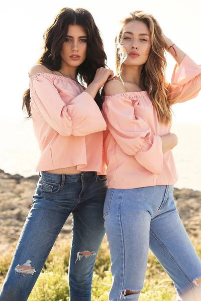 Duas meninas bonitas em roupas casuais posando ao ar livre — Fotografia de Stock