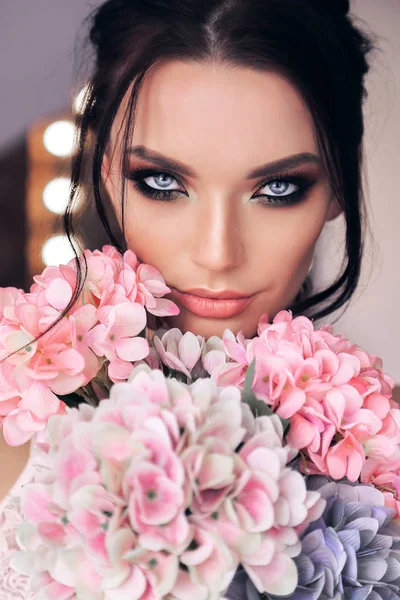 Belle femme aux cheveux foncés et maquillage du soir avec des fleurs — Photo