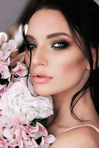 Piękna kobieta, ciemne włosy i makijaż wieczór z kwiatami — Zdjęcie stockowe