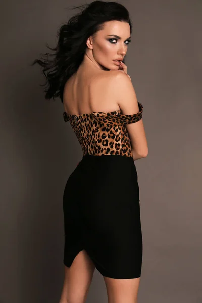 Krásná žena s tmavými vlasy v elegantní oblečení pózuje v hřebčíně — Stock fotografie