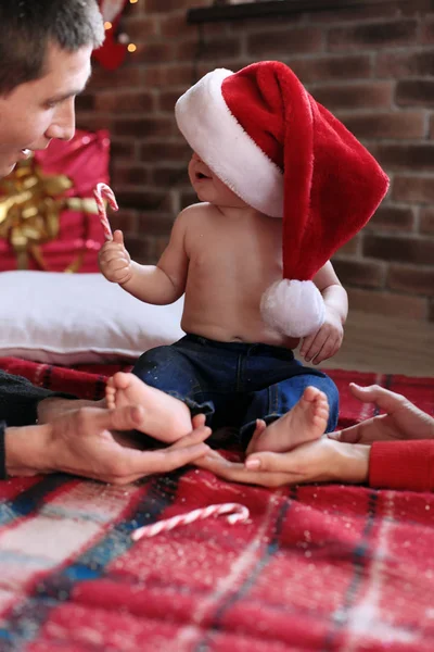 Ładny chłopczyk w Santa hat pozowanie w pobliżu choinki — Zdjęcie stockowe