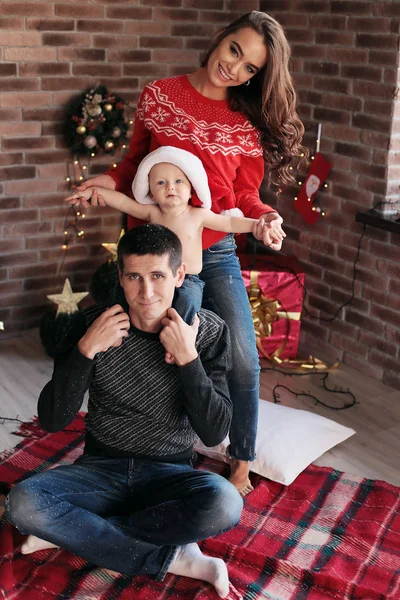 Mooie en gelukkige familie poseren in de buurt van de kerstboom — Stockfoto