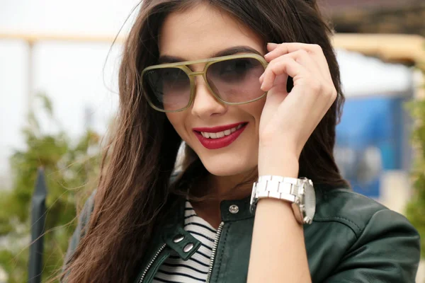 Beautiful girl with dark hair in casual clothes posing near auto — Stock Photo, Image