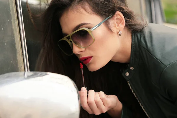 Vacker flicka med mörkt hår i casual kläder poserar nära auto — Stockfoto