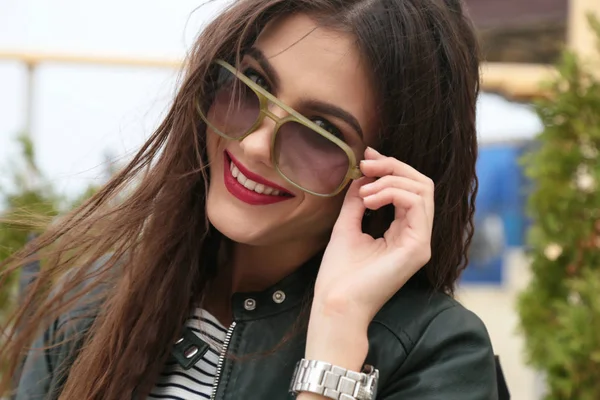 Menina bonita com cabelo escuro em roupas casuais posando perto de auto — Fotografia de Stock