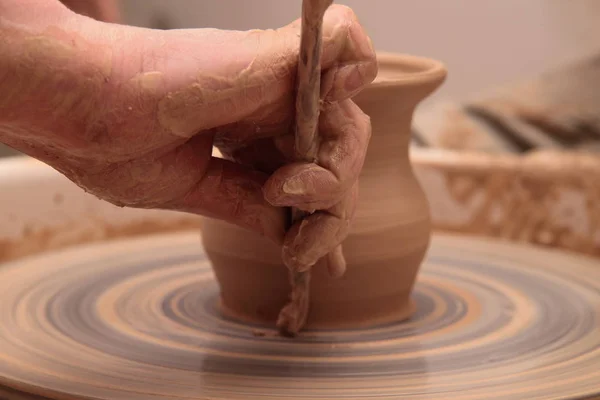 Mains d'un potier, la création d'un pot de terre sur la roue de poterie . — Photo