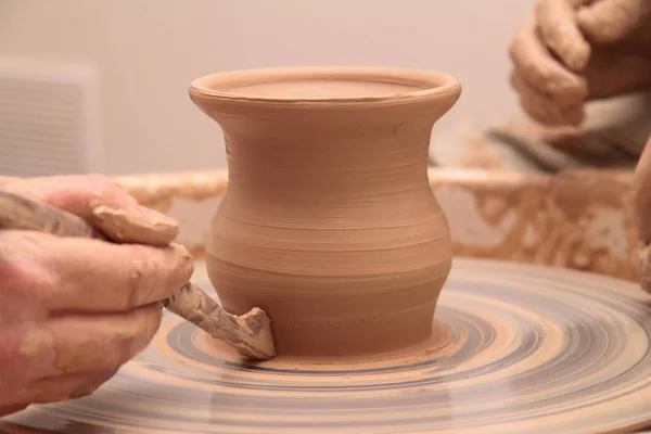 Manos de un alfarero, creando un frasco de barro en la rueda de cerámica . — Foto de Stock