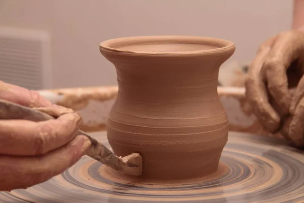 Manos de un alfarero, creando un frasco de barro en la rueda de cerámica . — Foto de Stock