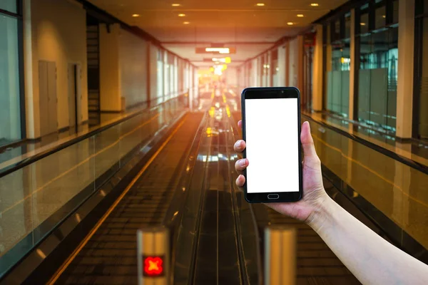 Smartphone ile arka plan bulanık, yürüyen merdiven geçit tutan el