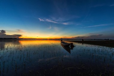 Gün batımı arka plan ile gölde tekne