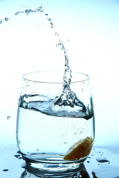 Salpicadura de agua en vidrio de rodajas de mandarina que caen —  Fotos de Stock